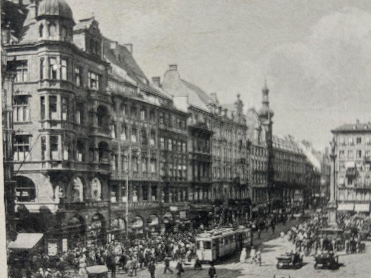 Cartolina fotografica della Marienplatz e del municipio durante il carillon, con folla e un tram